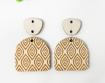 May include: A pair of unfinished wooden earrings with a geometric pattern. The earrings are made of two pieces, a top piece with a hole for a hook and a bottom piece with a geometric pattern.