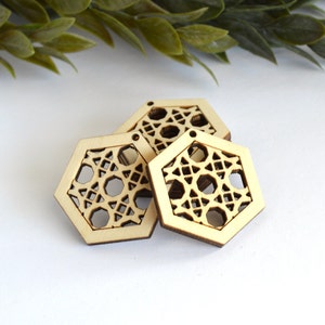 May include: Three unfinished wooden hexagon shapes with intricate laser cut designs. The hexagons are stacked on top of each other.