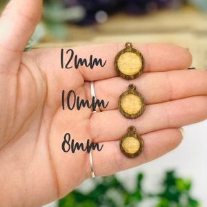 May include: Three wooden round pendant blanks with a hole at the top. The blanks are 8mm, 10mm, and 12mm in diameter.