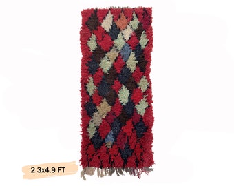 May include: A red, black, and white patterned rug with a geometric design. The rug is 2.3 feet wide and 4.9 feet long.