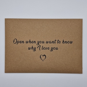 K&ouml;nnte beinhalten: Ein brauner Papierumschlag mit dem Text "Open when you want to know why I love you" und einem kleinen gezeichneten Herzen.