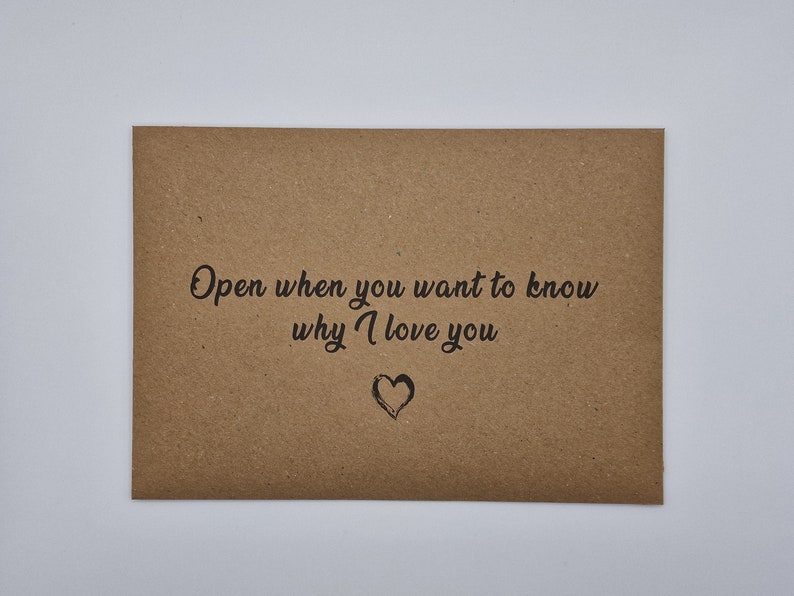 K&ouml;nnte beinhalten: Ein brauner Papierumschlag mit dem Text "Open when you want to know why I love you" und einem kleinen gezeichneten Herzen.