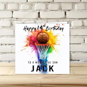 K&ouml;nnte beinhalten: Quadratische Geburtstagskarte mit dem Text "Happy 14th Birthday" und "To a Wonderful Son JACK". Die Karte zeigt einen Basketball, der in einen Korb geht, mit einem farbenfrohen Spritzer-Hintergrund.