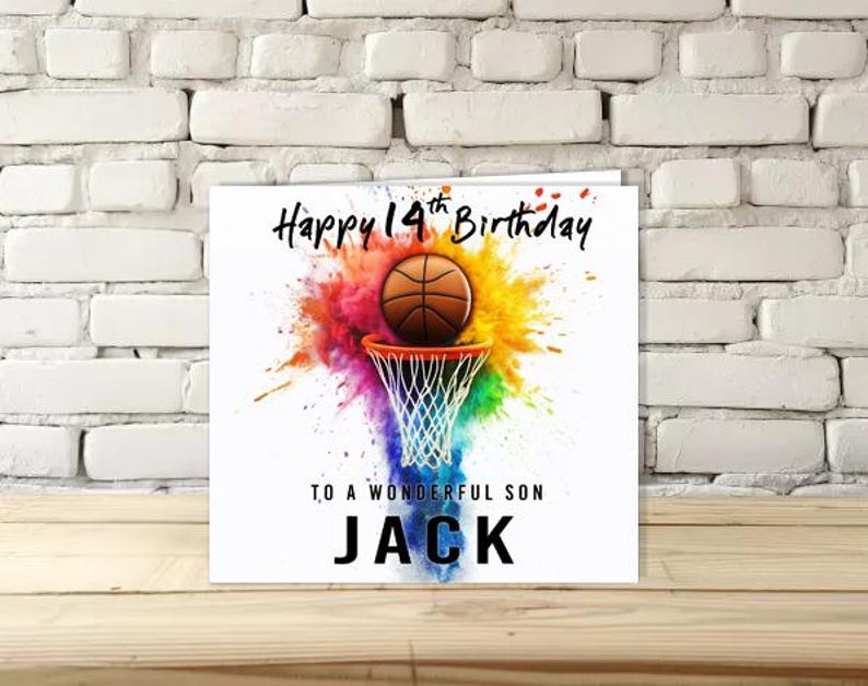 K&ouml;nnte beinhalten: Quadratische Geburtstagskarte mit dem Text "Happy 14th Birthday" und "To a Wonderful Son JACK". Die Karte zeigt einen Basketball, der in einen Korb geht, mit einem farbenfrohen Spritzer-Hintergrund.