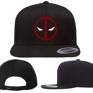 May include: Black and red embroidered baseball cap with a Deadpool logo. The logo is a red circle with a white outline and a white mask with red eyes inside.