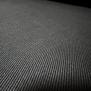 Puede incluir: Primer plano de una tela gris oscuro texturizada con un patr&oacute;n acanalado. La tela parece estar tejida, con l&iacute;neas verticales visibles y una superficie ligeramente irregular, creando una sensaci&oacute;n de profundidad y textura. La iluminaci&oacute;n resalta el tejido.