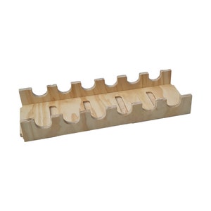 May include: A wooden wine bottle holder with six slots. The holder is made of light brown wood and has a natural finish.