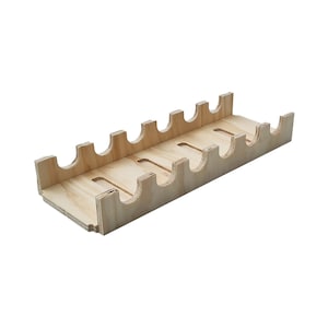 May include: A wooden tray with eight slots for holding bottles or other items. The tray is made of light-coloured wood and has a simple, rectangular design.