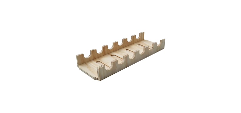 May include: A wooden tray with eight slots for holding bottles or other items. The tray is made of light-coloured wood and has a simple, rectangular design.