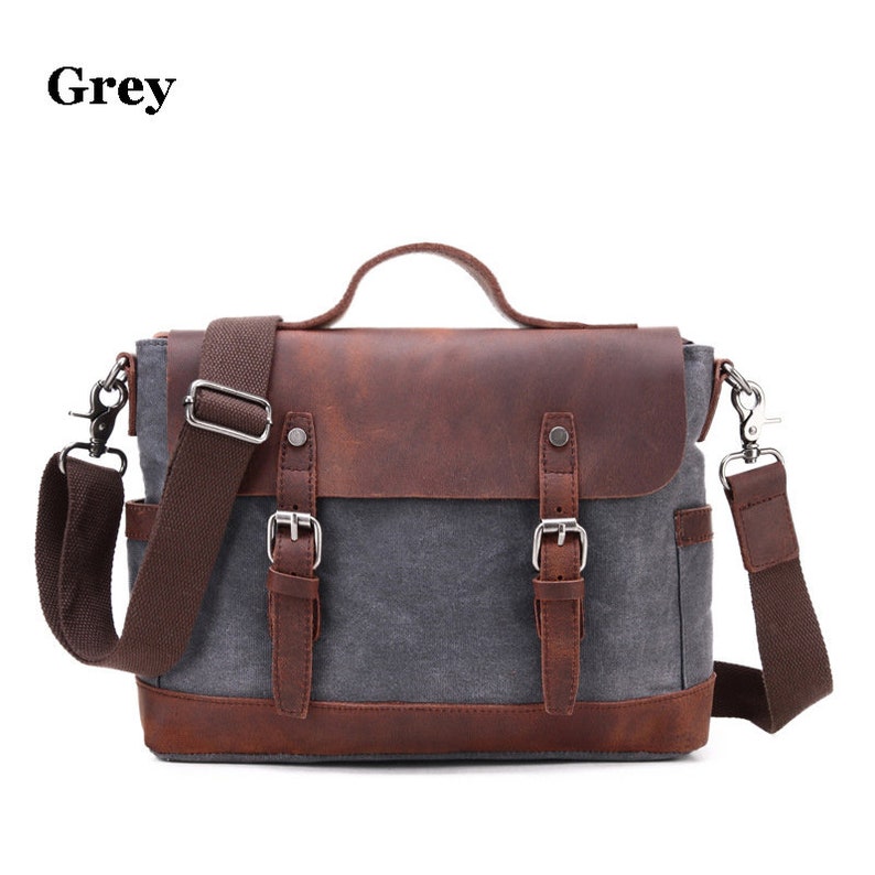 May include: Grey messenger bag with a brown leather flap and accents. The bag has a handle, adjustable shoulder strap, and two buckle closures. The word "Grey" is printed in the upper left corner.