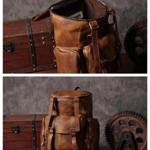 May include: A brown leather backpack with multiple pockets and adjustable straps. The bag has a vintage, worn look. A wooden chest and a metal gear are in the background, suggesting a rustic or industrial theme.