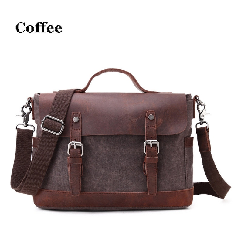 May include: A brown messenger bag with a leather flap and accents. The bag has a canvas body, a top handle, and a shoulder strap. The text "Coffee" is in the upper left corner. The bag has two buckles and a side pocket.