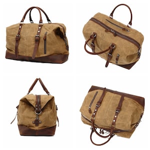 May include: A tan canvas duffel bag with brown leather accents. The bag features a top handle, shoulder straps, and multiple zippered compartments. The bottom and trim are made of brown leather.