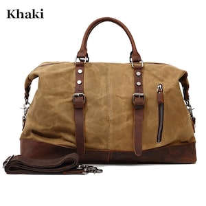 May include: Khaki canvas duffel bag with brown leather accents. Features include a top handle, shoulder strap, and a side zipper pocket. The bag has a rectangular shape and metal hardware.