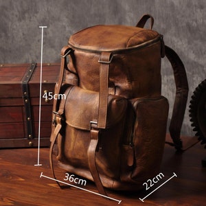 May include: A brown leather backpack with multiple pockets and adjustable straps. The backpack measures 45cm high, 36cm wide, and 22cm deep (approximately 17.7 inches high, 14.2 inches wide, and 8.7 inches deep). It has a zippered main compartment and a flap pocket.