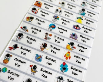 May include: A sheet of white labels with colorful astronaut illustrations. Each label has the names "Samson" and "Van" printed on it.