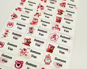 May include: A sheet of rectangular name labels featuring various pink cartoon bear illustrations. Each label includes the name "Samson Van" in black text, with additional words like "sweet", "cute", and "lucky" on some labels.