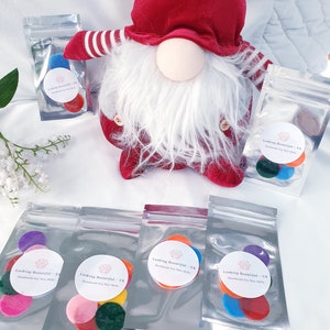 May include: Five small bags containing colourful soy wax melts. Each bag has a label that reads "Looking Beautiful - UK Handmade Soy Wax Melts".