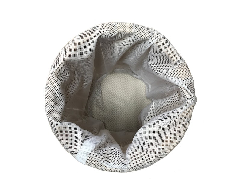 May include: A white mesh laundry bag, viewed from above, against a white background. The bag is cylindrical with a drawstring closure. The mesh has small, evenly spaced holes. The interior of the bag is visible.