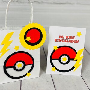 Puede incluir: Una bolsa de regalo de papel blanco con una estrella amarilla, un rayo amarillo y un dise&ntilde;o de Pok&eacute; Ball rojo y blanco. La bolsa est&aacute; atada con una cinta amarilla. Una tarjeta blanca con una estrella amarilla, un rayo amarillo y un dise&ntilde;o de Pok&eacute; Ball rojo y blanco dice "Du bist eingeladen" en texto negro.