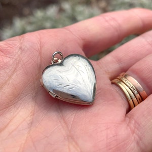 Peut inclure: Un médaillon en argent en forme de cœur avec un motif gravé. Le médaillon est ouvert et prêt à accueillir une photo ou un autre petit trésor.