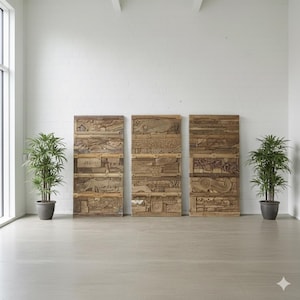 Könnte beinhalten: Drei rechteckige Wandpaneele aus Holz mit geschnitzten Reliefdesigns. Die Paneele bestehen aus hellbraunem Holz und sind vertikal angeordnet. Die Schnitzereien zeigen verschiedene Figuren und Muster. Zwei Topfpflanzen flankieren die Paneele.