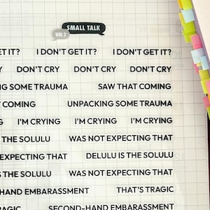 以下が含まれることがあります： 黒い文字が書かれた透明なステッカーのシート。ステッカーには、「泣かないで」「それは来ると思った」「デルルはソルール」「セカンドハンドの恥ずかしさ」「それは悲劇だ」「ただコミュニケーションを取ろう！」「それは痛かった」「それについて話そう」「プロットツイスト」「わかる」「セカンドリードシンドローム」などのフレーズが書かれている。