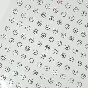 May include: A sheet of white sticker paper with a variety of black and white cartoon faces. The faces have different expressions, including happy, sad, surprised, and confused.