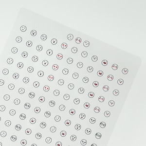May include: A sheet of clear sticker paper with a variety of black and white emoji faces. The emojis include smiling, frowning, surprised, and hearts for eyes.
