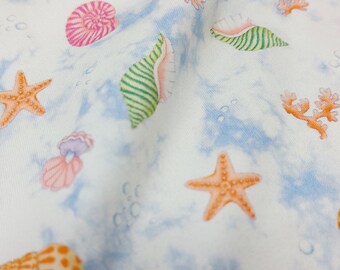 Cotton jersey with colorful shells and starfish on a natural and blue background, 145 cm wide, Oeko-Tex