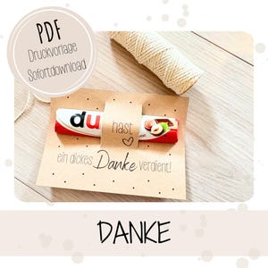 May include: A Kraft paper card with a chocolate bar, a twine roll, and the word "DANKE" in black. The card has the text "PDF Druckvorlage Sofortdownload" in a circle and "du hast ein dickes Danke verdient!" below the chocolate.