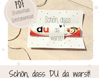 May include: A white card with black polka dots and the text "Schön, dass du da warst!" surrounds a chocolate bar. The card also has a circular graphic with the text "PDF Druckvorlage Sofortdownload".