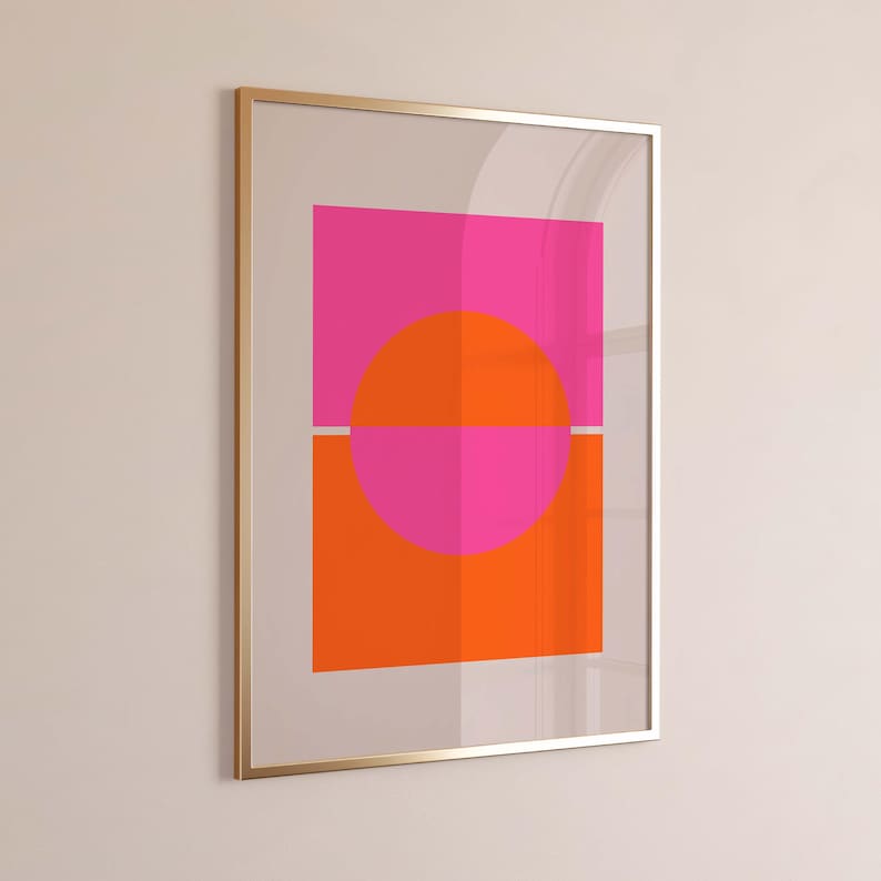 May include: Abstract geometric art print with a pink and orange color scheme. A large circle is divided in half by a thin white line, with the top half pink and the bottom half orange. The circle is centered within a square frame.