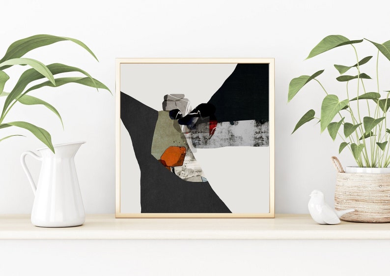 May include: Abstract art print in a wooden frame with black, white, gray, green, orange, and red colors. The print is on a white background and features geometric shapes.