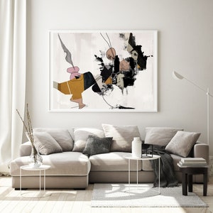 May include: Abstract art print in black, white, brown, and pink colors. The print features geometric shapes and lines on a white background. The print is framed in a white frame and is hanging on a white wall above a beige sectional sofa.