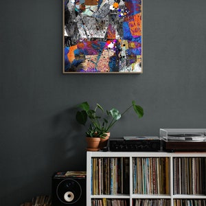 Pu&ograve; includere: Un'unit&agrave; a scaffale bianca con sei scomparti pieni di dischi in vinile. Un altoparlante nero si trova sul lato sinistro dello scaffale e un giradischi si trova sopra lo scaffale. Un dipinto astratto incorniciato con un design geometrico colorato &egrave; appeso al muro dietro lo scaffale.