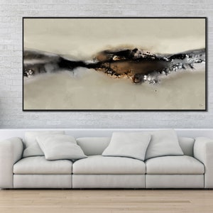 May include: Abstract art print with a black frame, featuring a brown and gray landscape with a white background. The print is hanging on a white brick wall above a white couch.