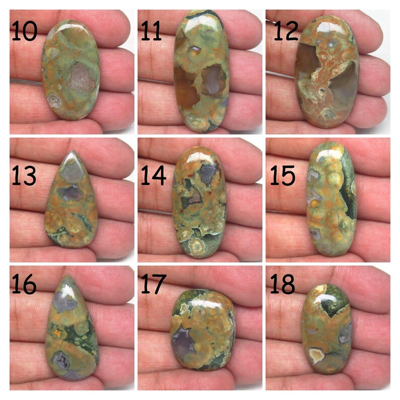 May include: Nine oval and teardrop shaped green, brown, and gray jasper cabochons with a polished finish. The cabochons are numbered 10 through 18.