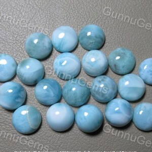 May include: A collection of 18 round, light blue cabochon gemstones with a marbled pattern.