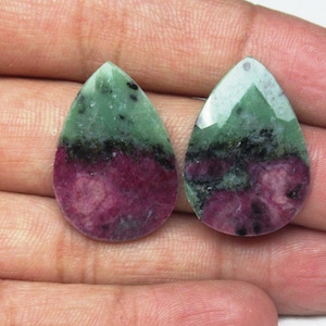 Może przedstawiać: Dwa zielono-różowe kamienie szlachetne w kształcie łzy z czarnymi plamkami.