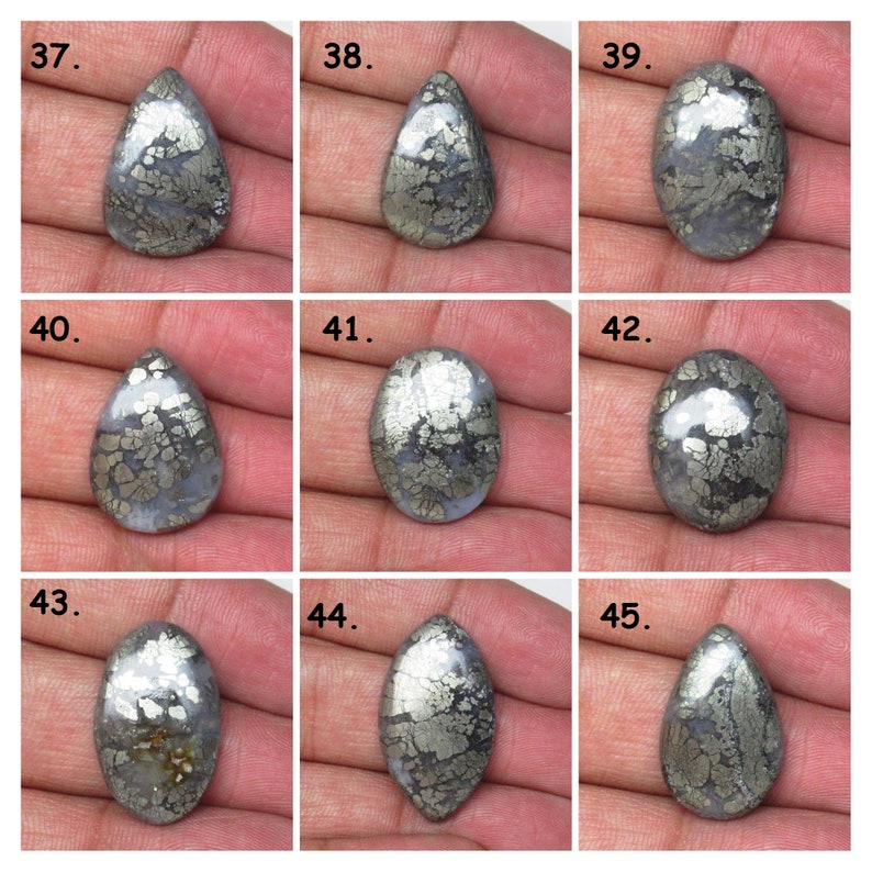 May include: Nine silver and gray pear-shaped and oval cabochon gemstones with a pyrite pattern.