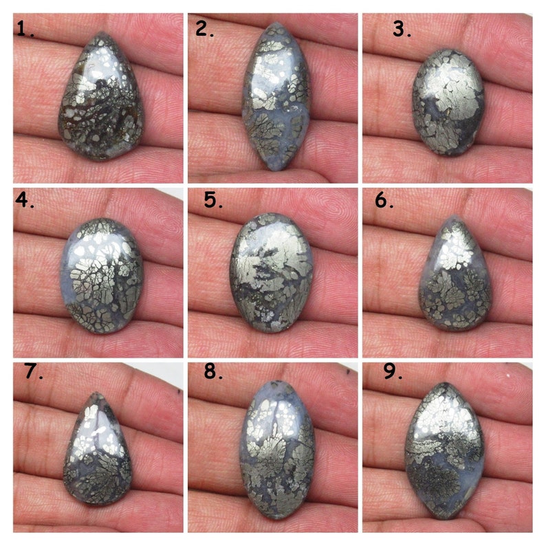 May include: Nine cabochon gemstone cabochons with a silver and gray color. The cabochons have a unique pattern of silver pyrite inclusions.
