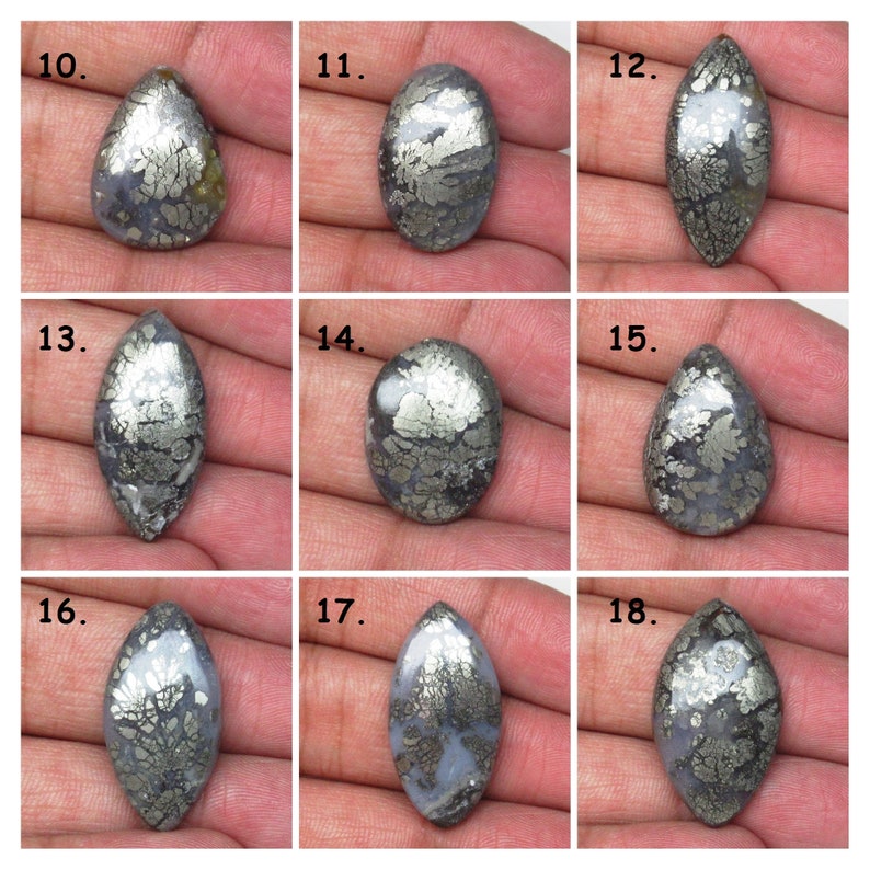 May include: Nine cabochon cut, pear-shaped, silver and black, dendritic agate gemstones. The stones are arranged in three rows of three.