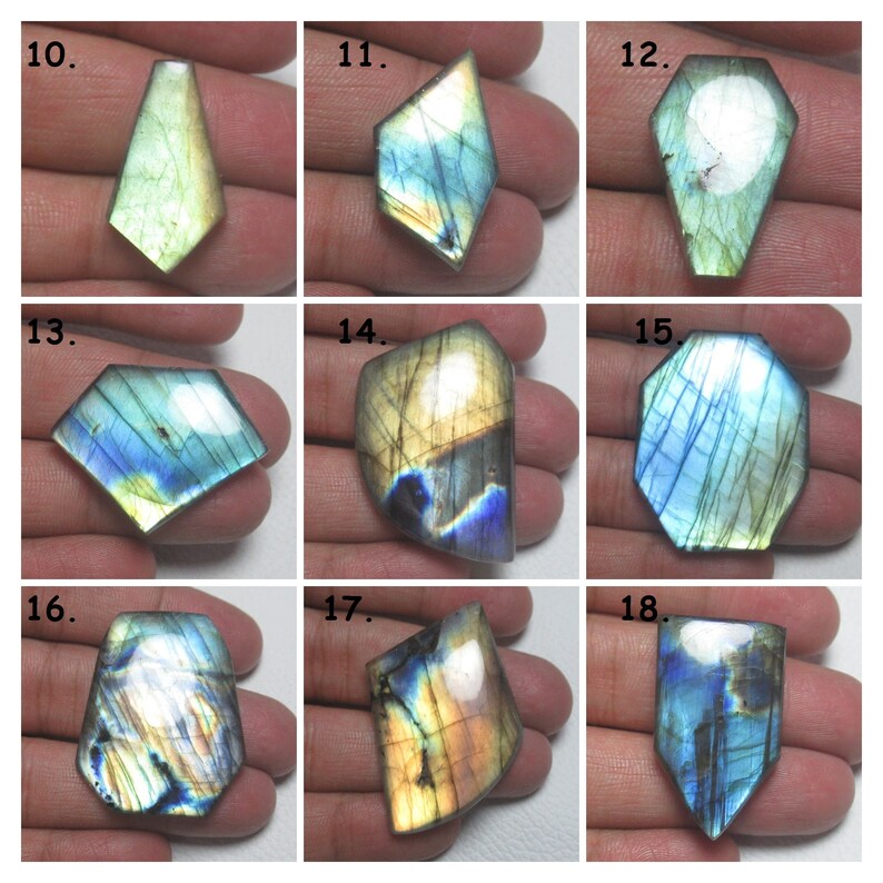 May include: Assortment of 9 iridescent labradorite gemstone cabochons in various shapes and sizes. The cabochons are a mix of blue, green, and gold colors.