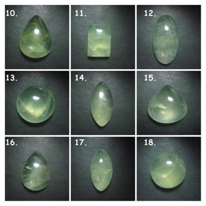 May include: Nine green gemstone cabochons in various shapes, including oval, round, teardrop, and square, displayed on a black background. The gemstones are translucent and have a light green colour.