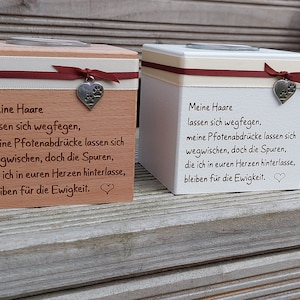 Op de afbeelding: Twee houten kaarshouders met een wit lint en een rood lint. De kaarshouders hebben een pootprintbedel en een boodschap die luidt: "Mijn haar kan weg zijn, maar de pootstappen die ik in je hart achterlaat, blijven voor altijd."