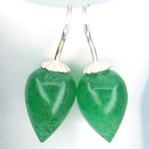 May include: A pair of silver dangle earrings with green teardrop-shaped stones.