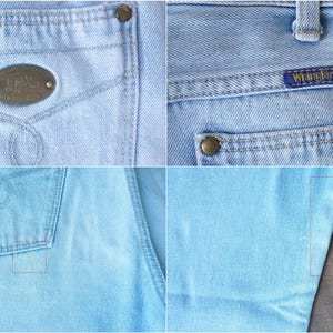 May include: Close-up of light blue denim jeans. Details include a back pocket with a small logo, a front pocket with a metal emblem, and the "Wrangler" label. The jeans have metal rivets and a classic design.