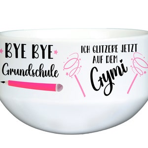 Könnte beinhalten: Weiße Keramikschüssel mit einem rosa Bleistift und dem Text "BYE BYE Grundschule" auf der einen Seite und rosa Zauberstäben mit Sternen und dem Text "ICH GLITZERE JETZT AUF DEM GYMI" auf der anderen Seite.