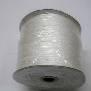 May include: A spool of white cord wrapped in clear plastic. The cord is wound around a silver metal spool with a hole in the center.